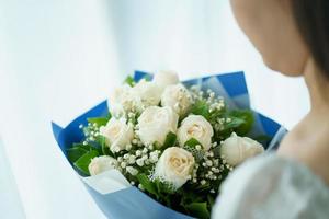 mujer joven asiática feliz sosteniendo un hermoso ramo de flores. foto