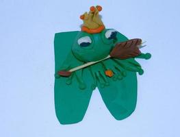 Green frog of plasticine, with a crown. photo