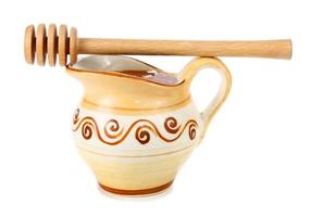 honey in a jug and wooden stick photo