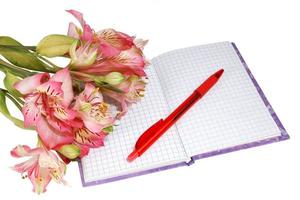 notebook with a pen and flowers photo