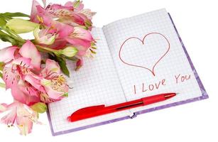 cuaderno con flores junto a un corazón e inscripción foto