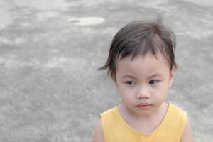 Asian girl, little toddler child with adorable short hair making frustrated face. photo