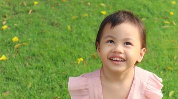 retrato de feliz riendo encantadora niña asiática de 3 años de edad, pequeña niña pequeña con adorable cabello corto. foto