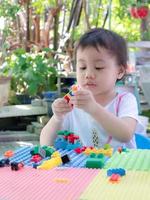 niño en edad preescolar jugando bloques de construcción coloridos creativos en casa. foto