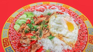 Stir fried duck with chilli and basil, Thai spicy food eat with sunny side up fried egg and cucumber on the side. Call pad kra pao in Thai. photo