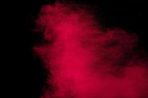 Pink powder explosion.Pink dust splash cloud on dark background. photo