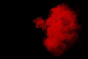 Red powder explosion cloud on black background. photo