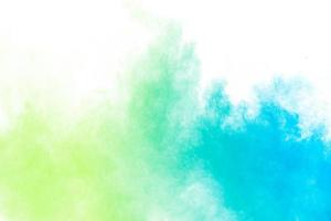 Abstract blue green powder explosion on white background.Freeze motion of blue green dust cloud. photo