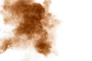 Brown dust explosion cloud.Brown particles splatter on white background. photo