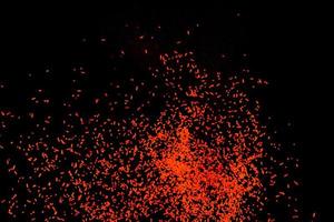 explosión de partículas de polvo naranja sobre fondo negro. foto