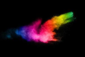 Multicolored powder explosion on black background.Color dust splash cloud on dark background.Launched colorful particles. photo