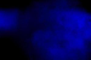 explosión de polvo azul rojo abstracto sobre fondo negro. movimiento congelado de salpicadura de polvo azul rojo. holi pintado en festival foto