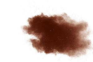 Freeze motion of brown powder exploding. Abstract design of color powder cloud against white background. photo