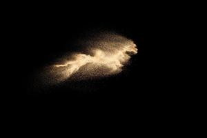 Dry river sand explosion isolated on black background. Abstract sand cloud.Brown colored sand splash against dark background. photo