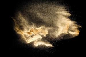 Dry river sand explosion isolated on black background. Abstract sand cloud.Brown colored sand splash against dark background. photo