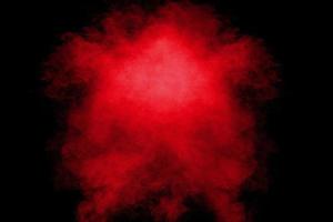 Red orange color powder explosion cloud  on black background. photo