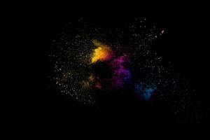 Launched multicolored powder on black background.Color powder explosion.Colorful dust splashing. photo