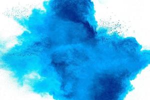 Bizarre forms of blue powder explosion cloud on white background.Launched blue dust particles splashing. photo