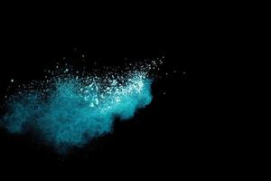 Abstract splash of green colored powder on black background.Green powder explosion. photo