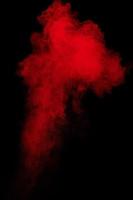 Red powder explosion cloud on black background. photo