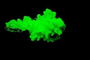 Green acrylic ink in water.Abstract paint splash cloud isolated on black background. photo