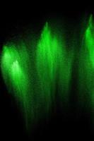 Green particles explosion on black background. Color dust splash use for abstract background. photo