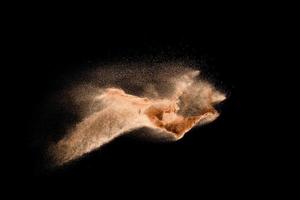 Dry river sand explosion isolated on black background. Abstract sand cloud.Brown colored sand splash against dark background. photo