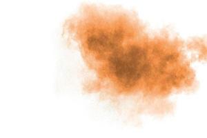 Freeze motion of brown powder exploding. Abstract design of color powder cloud against white background. photo