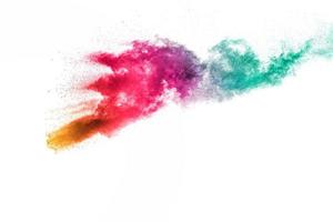 Abstract multi color powder explosion on white background.Freeze motion of dust particles splash. photo