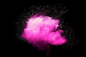 Pink powder explosion.Pink dust splash cloud on dark background. photo