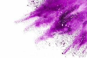 explosión de partículas púrpuras sobre fondo blanco. congelar el movimiento de salpicaduras de polvo púrpura sobre el fondo. foto