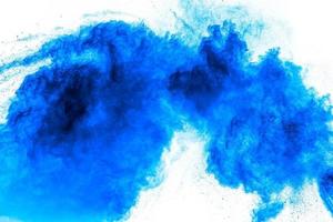 Bizarre forms of blue powder explosion cloud on white background.Launched blue dust particles splashing. photo