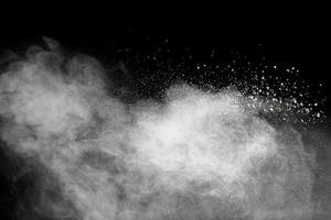 White powder explosion cloud against black background.White dust particles splash. photo