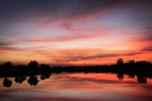 Sunset over lake with red orange sky. photo