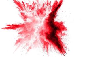 Abstract red dust splattered on white background. Red powder explosion.Freeze motion of red particles splash. photo