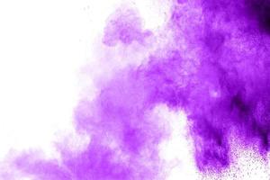 Purple color powder explosion cloud  on white background.Closeup of purple dust particles splash on background. photo