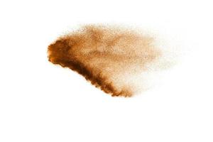 Abstract  brown color sand splash on white background. Brown dust particles explosion on background, throwing freeze stop motion concept. photo