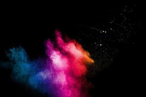 Abstract colorful powder explosion on black background.Freeze motion of dust splash.Painted Holi. photo