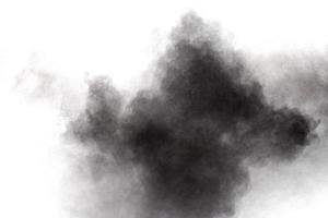 Black powder explosion on white background.Black dust particles splash. photo