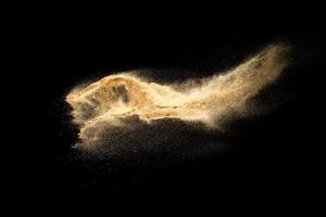 Dry river sand explosion isolated on black background. Abstract sand cloud.Brown colored sand splash against dark background. photo