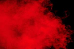 Red particles explosion on black background.Freeze motion of red dust splash. photo