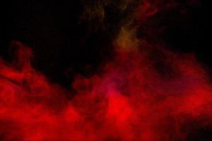 Red particles explosion on black background.Freeze motion of red dust splash. photo