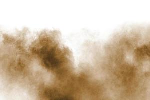 congelar el movimiento de la explosión de polvo marrón. detener el movimiento del polvo marrón. polvo marrón explosivo sobre fondo blanco. foto