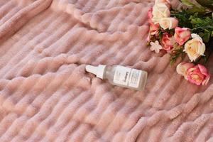 The Ordinary cosmetics, bottle on bed, lifestyle staging, Vitoria, Spain, April of 2022 photo