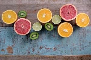 Pattern of citrus - orange, grapefruit, lemon, lime fruit and kiwi on the wooden background photo