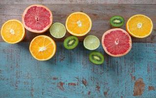Pattern of citrus - orange, grapefruit, lemon, lime fruit and kiwi on the wooden background photo
