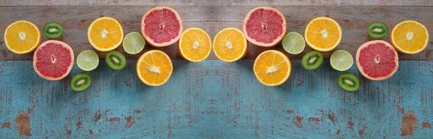 Pattern of citrus - orange, grapefruit, lemon, lime fruit and kiwi on the wooden background photo