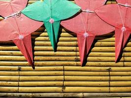 Top view of green and red star-shaped kites on bamboo litter in Thai art of craft concept photo