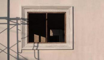 vista frontal del marco de la ventana con sombra de andamio en la superficie de la pared de hormigón en el sitio de construcción de la casa foto