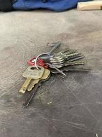 Set of eleven house keys on the ring on work-table. work-table background and set of keys photo